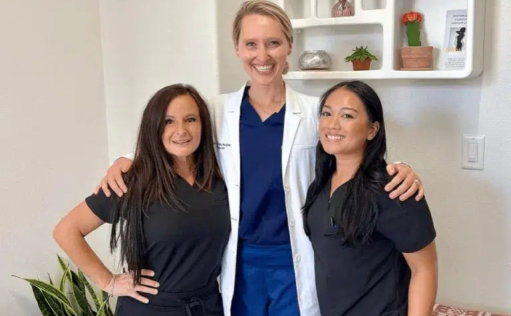 Three women in scrubs standing side by side