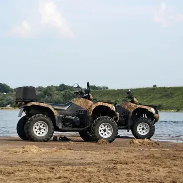 ATV parked on the sandy shore of the lake